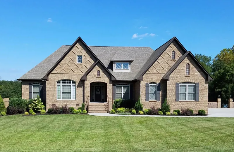 Stone Covered Two-Story Home Has Country Style And Looks Like A One-Story Style