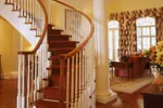 Curving staircase is graceful leading to the second floor.
