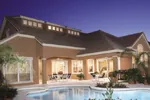 Mediterranean stucco home with luxurious pool and covered outdoor living area.