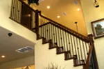 Intricate stairwell with access to foyer and kitchen.