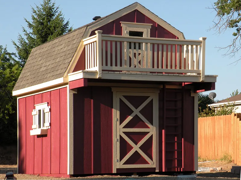 Storage shed with playhouse loft has an outdoor ladder that leads to a second story balcony