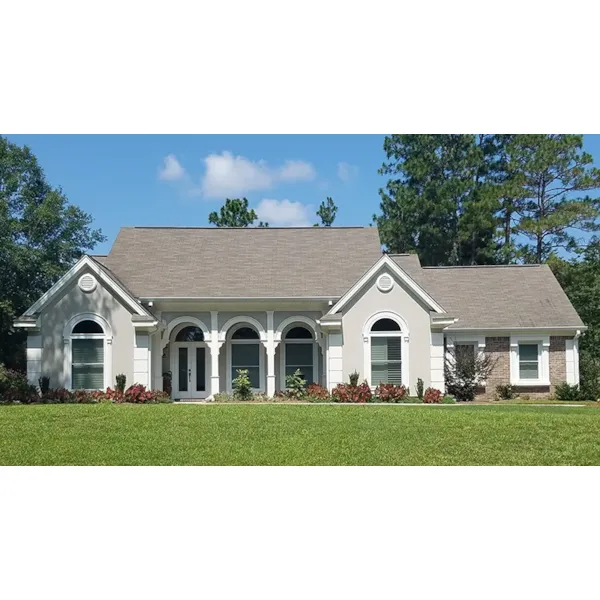 Three Arches Top The Covered Porch Of This Beautiful Stucco House