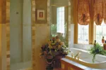 Master bathroom's shower with decorative tile and lavish whirlpool tub.