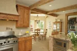 A rustic stone floor, wood ceiling beams and honey-stained cabinetry create a kitchen with great country style perfect for casual family meals and food preparation.