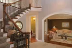 The intricate double staircase can be accessed in both the foyer and kitchen and leads to the second floor living spaces while highlighting the two-story ceiling and decorative nooks.