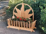 All wood ground level planter has sun shaped motif design on the back