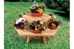 Small hexagon wood picnic table holds multiple clay flower pots