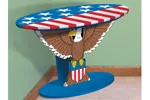 This patriotic table has a bald eagle design as the stand with a stars and stripes pattern on the top