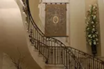 The stunning two-story foyer has a circular staricase adorned with a mediterranean style wrought-iron railing. As the staircase ascends to the second floor it offers an artistic Old World feel to the interior.