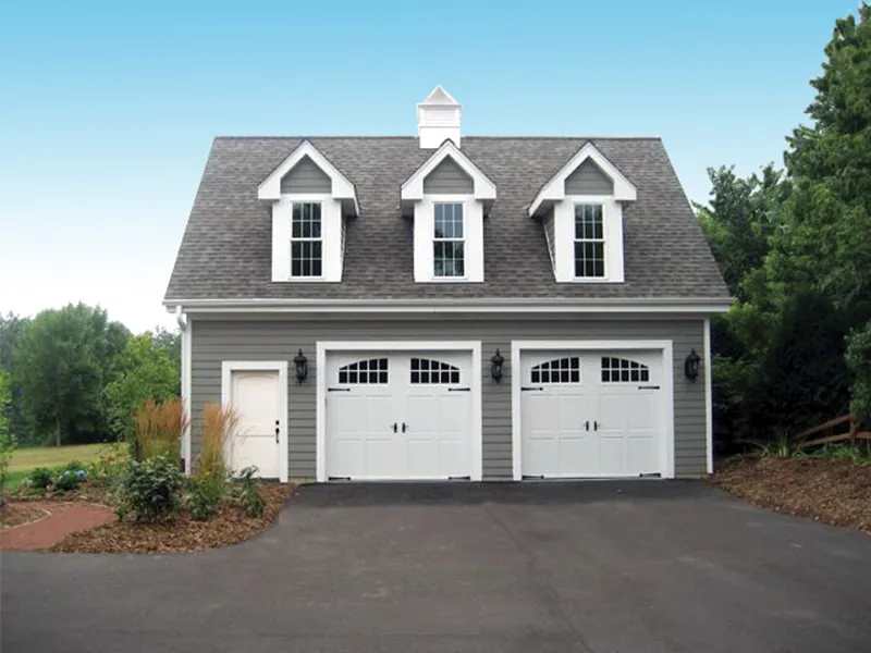 Two-car garage enjoys the Colonial style of three roof dormers and a handy entry door