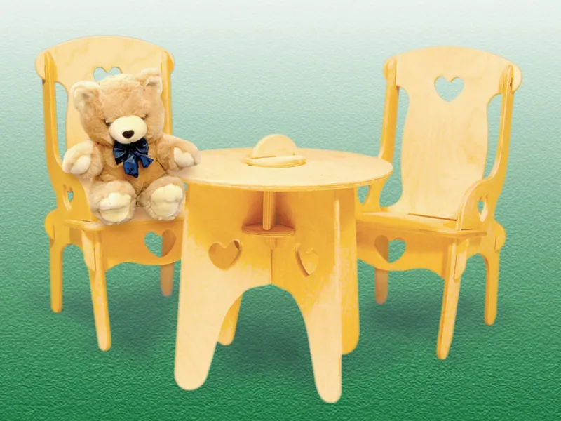 This doll's table and chairs includes a table with heart cut-outs and two chairs of the same design